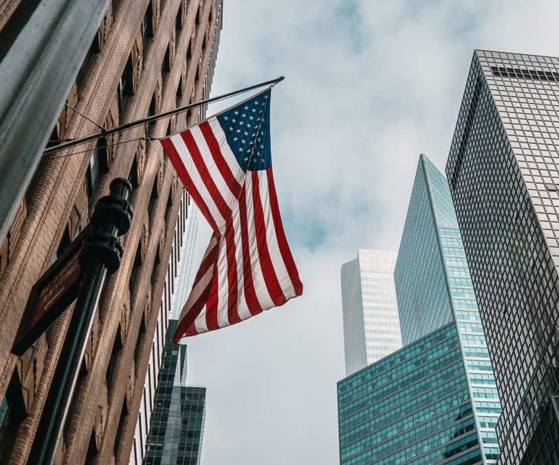 Drapeau des États unis d'Amérique accroché à une façade avec des buildings en fond